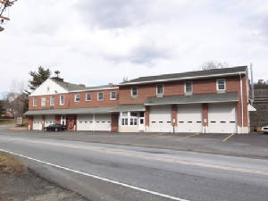 The Union Fire Company building on River Road in Titusville, NJ — two-story brick hall with three garage bays and a residential addition.